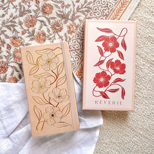 Reverie Traveler Size Journal in a light beige color with gold foil floral design on cover. With watercolor dotted paper