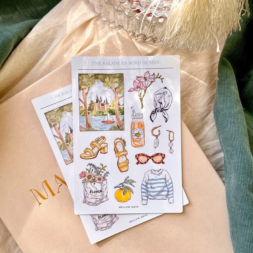 vinyl sticker sheet for bujo, journaling, and stationery planners with theme of a summer seaside vacation with stickers of a seaside city scenery, silk scarf, orange juice, sandals, nautical shirt, sunglasses, earrings, fruit, and flowers